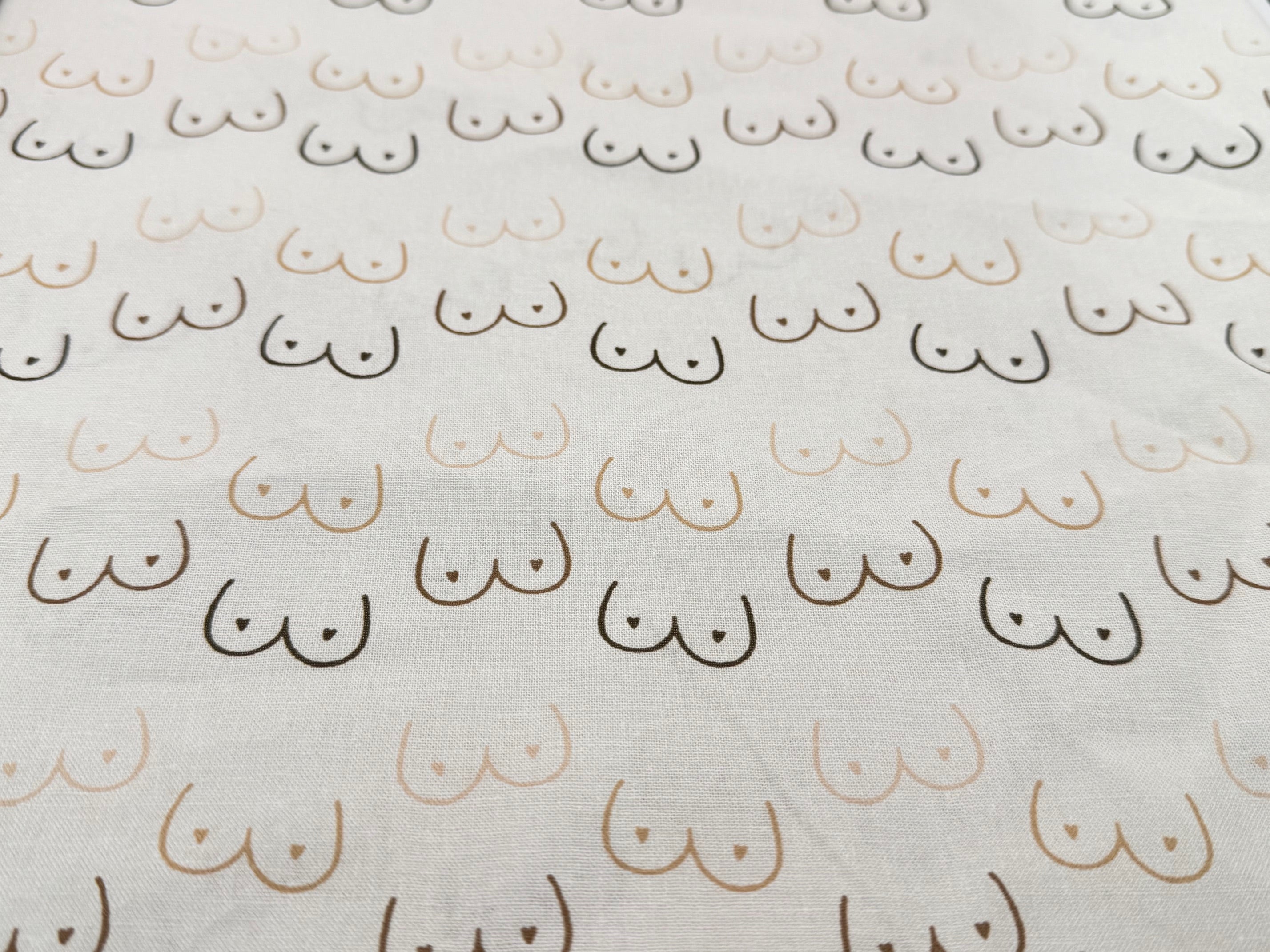 Pattern of boobies on cream cotton fabric