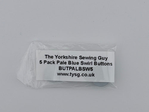 A small clear plastic bag containing a white paper label with black text reading 'The Yorkshire Sewing Guy 5 Pack Pale Blue Swirl Buttons BUTALBSWS www.tyalbsws.