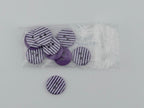 A set of round buttons with a purple and white striped pattern, shown both loose and inside a clear plastic bag on a light gray background.