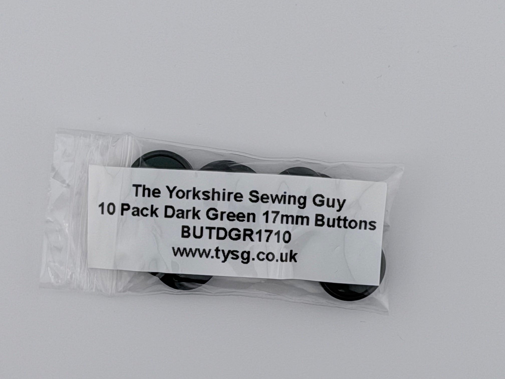 A small clear plastic bag containing 10 dark green buttons, with a white paper label that reads 'The Yorkshire Sewing Guy', 'BUTDGR1710', and 'www.tysg.co.uk'