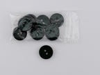 A pack of dark green buttons, including a single loose button shown to the left of the clear plastic bag containing six round buttons.